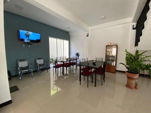 a dining room with a table and a tv on a wall at Mountain White Villa by Sunrise in Kandy