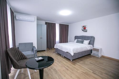 a bedroom with a bed and a chair and a table at Apartments Monik Sandanski in Sandanski