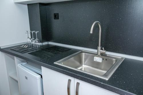 a kitchen with a sink and a black counter top at Apartments Monik Sandanski in Sandanski