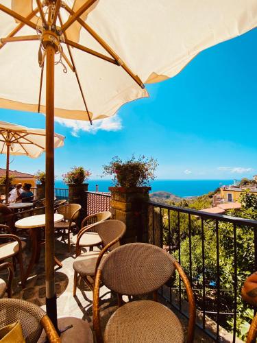 a patio with tables and chairs and an umbrella at Sdraiati Pollica - Apartments - Bed & Breakfast in Pollica