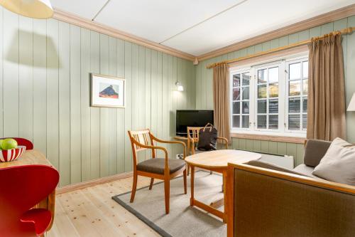 uma sala de estar com uma mesa e uma cadeira em Ilsetra Hotell em Hafjell