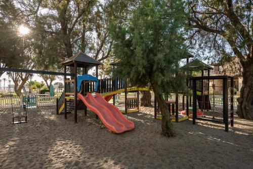 a playground with a slide and a tree at Caldera Creta Paradise in Plataniás