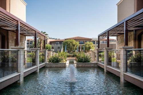 a fountain in the middle of a pond in a building at Caldera Creta Paradise in Plataniás