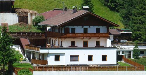ein großes weißes Haus mit braunem Dach in der Unterkunft Ferienwohnung Brandegg in Tux