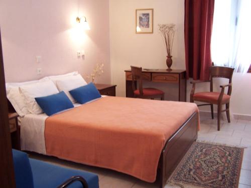 a hotel room with a bed and a table and chairs at Valia Calda Hotel in Perivoli