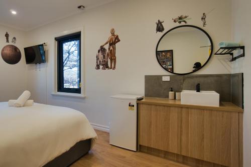1 dormitorio con cama, espejo y lavamanos en Dreamy Stays Accommodation - Private Rooms with Shared Bathrooms en Adelaida
