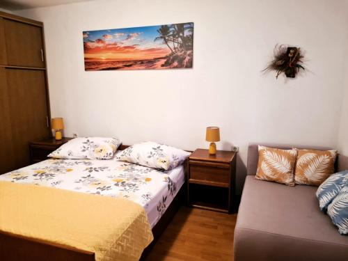 a small bedroom with a bed and a couch at Apartment Mužić in Cres