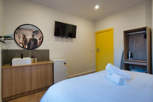 a bedroom with a bed and a tv on the wall at Dreamy Stays Accommodation - Private Rooms with Shared Bathrooms in Adelaide