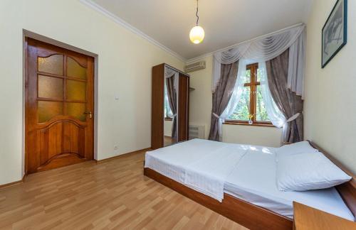 - une chambre avec un lit et une porte en bois dans l'établissement Alex Apartments near Independence Square - Kiev, à Kiev
