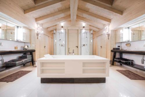 - une grande salle de bains avec une baignoire blanche au milieu dans l'établissement Chalet Migui Luxury Living & Spa *****, Crans Montana, à Crans-Montana