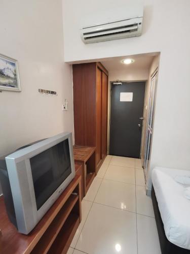 a living room with a tv and a bed at Sweet Star Hotel in Alor Setar