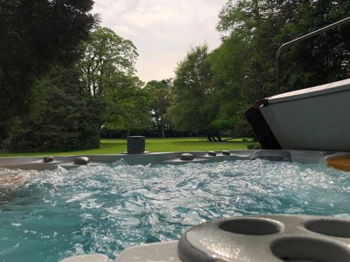 a jacuzzi tub with water and trees in the background at B&B en SPA Landgoed Matanze in Terwolde