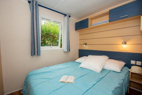 A bed or beds in a room at Camping de la Baie