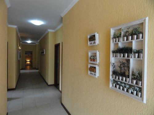 a hallway with shelves with plants on a wall at Village du Soleil in Cabo Frio