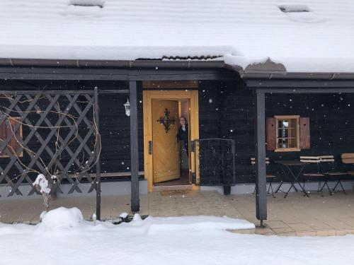 a person standing at the door of a building in the snow at Kranach 5 - Wohnen beim Wein in Gamlitz