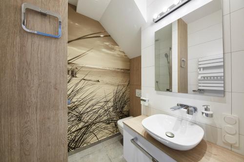 a bathroom with a sink and a mirror at Victus Apartamenty, Apartamenty Delux in Sopot