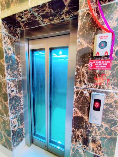 an elevator with blue doors and a sign on a wall at Perfectstayz Value Dwarkesh - Hotel Near Haridwar Railway station in Haridwār