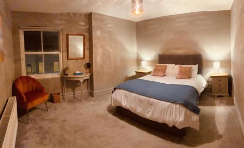 a bedroom with a bed and a desk and a window at 3 BEDROOM LUXURY APARTMENT Across the street from THE CASHEL PALACE HOTEL in Cashel