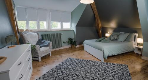 a bedroom with a bed and a chair in it at Les 3 Bérets chambres d'hotes in Oloron-Sainte-Marie