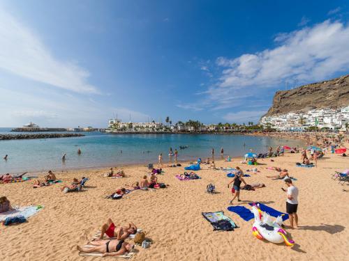 a group of people laying on a beach at FIRST LINE MOGAN BEACH - Parking free in Mogán