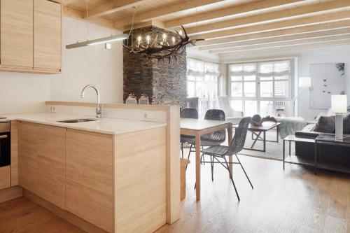 uma cozinha com um lavatório e uma mesa com cadeiras em Val de Ruda Luxe 43 by FeelFree Rentals em Baqueira-Beret