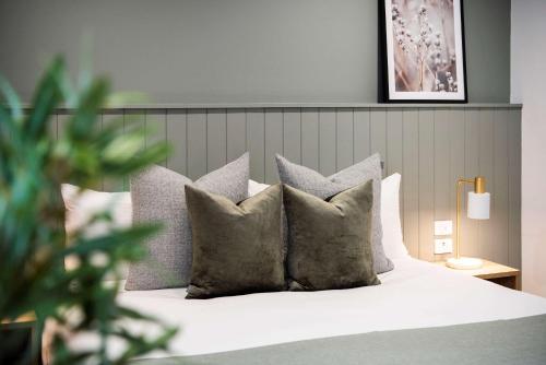 ein Schlafzimmer mit einem weißen Bett mit grauen Kissen in der Unterkunft Aden Hotel Mudgee in Mudgee
