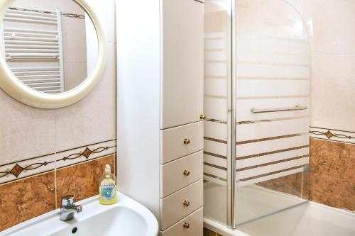 a bathroom with a shower and a sink and a mirror at Apartman LUI in Rijeka