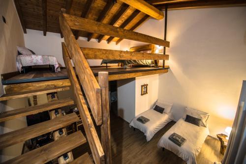 an attic room with two bunk beds and a ladder at Cascina Lunguria in Francavilla Bisio