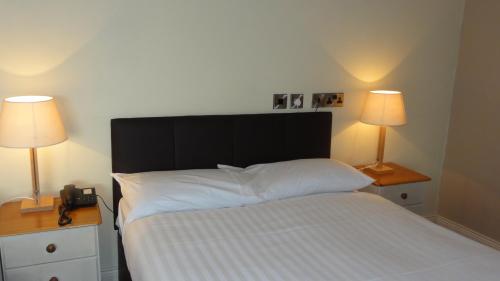 a bedroom with a bed with two nightstands and two lamps at Hannon's Hotel in Roscommon