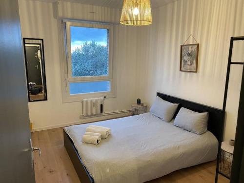 une chambre avec un lit avec deux serviettes dessus dans l'établissement Un Kiosque à Malo, à Dunkerque