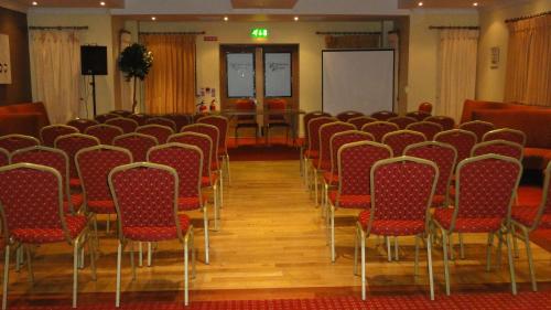 a conference room with red chairs and a whiteboard at Hannon's Hotel in Roscommon