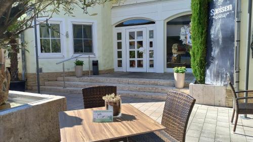 a wooden table and chairs in front of a building at Hotel Speeter in Weisenheim am Berg
