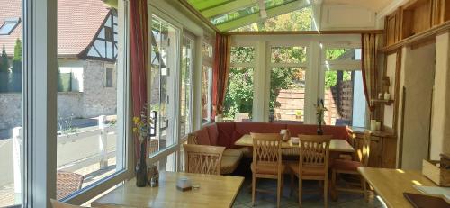 a conservatory with a table and chairs and windows at Hotel Speeter in Weisenheim am Berg