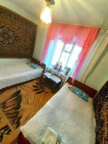 a small room with two beds and a window at Guesthouse Kishimzhan in Talas