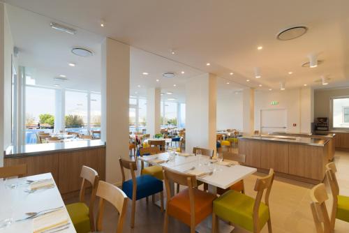 een restaurant met tafels en stoelen en een cafetaria bij Hotel Mediterraneo in Sottomarina