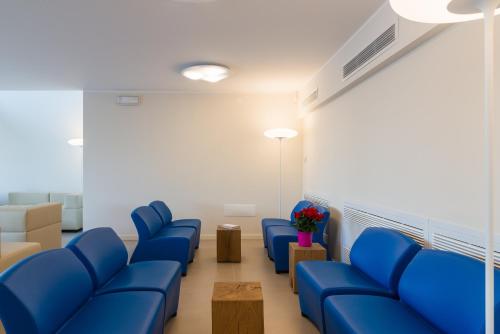 a waiting room with blue chairs in a hospital at Hotel Mediterraneo in Sottomarina