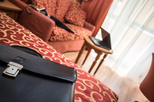 a black purse sitting on top of a couch at Sartori's Hotel in Trento