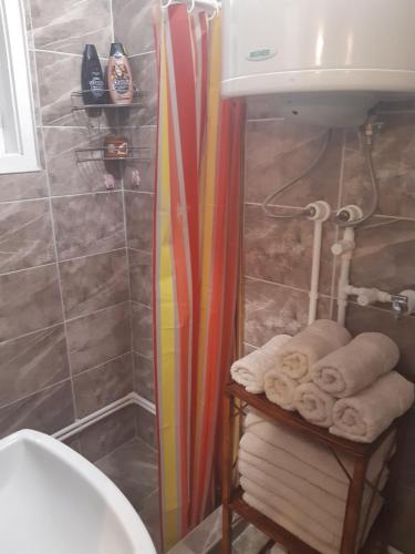 a bathroom with a shower and a sink and towels at Seosko turističko domaćinstvo Stojković in Aleksinac