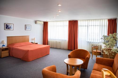 a hotel room with a bed and chairs at DIS Hotel in Cheboksary