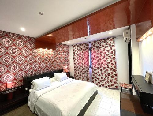 una camera da letto con un letto con carta da parati rossa e bianca di Maison de Vacances Harhoura a El Harhoura