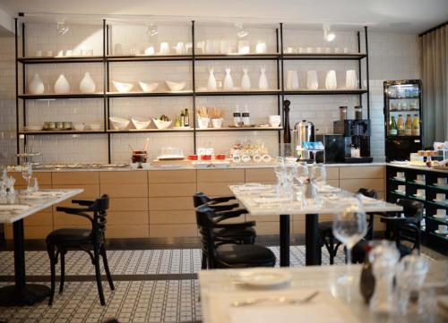 a restaurant with tables and chairs and dishes on shelves at Comm Hotel Poznań Airport in Poznań