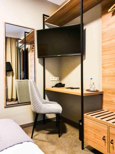 a bedroom with a loft bed with a desk and a chair at Comm Hotel Poznań Airport in Poznań