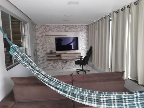 ein Wohnzimmer mit einem Sofa und einem TV in der Unterkunft Casa de Família in Capitólio
