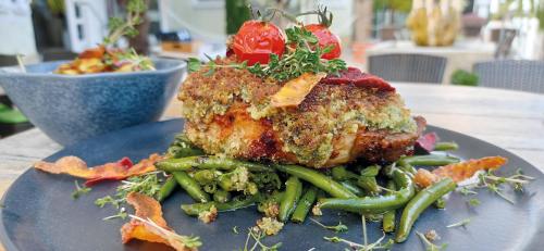 a plate of food with a piece of meat and green beans at Hotel Speeter in Weisenheim am Berg