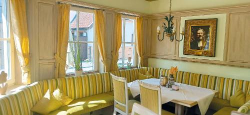 a restaurant with a table and a couch and windows at Hotel Speeter in Weisenheim am Berg