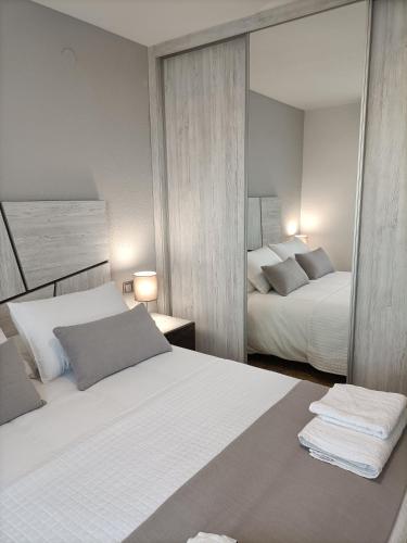 a bedroom with two beds and a mirror at Apartamento Laurel in Peniscola