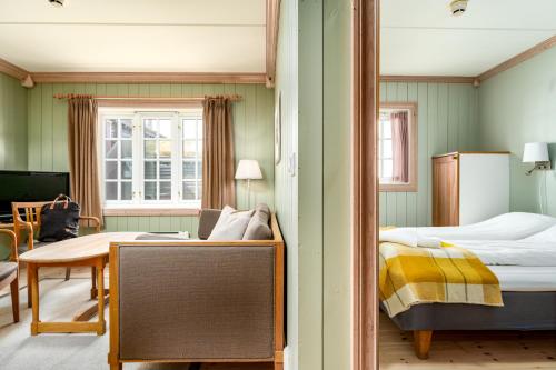 um quarto com um espelho, uma cama e uma mesa em Ilsetra Hotell em Hafjell