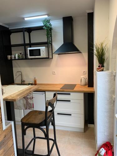 - une cuisine avec un bureau et une chaise dans la chambre dans l'établissement Le nid de cigognes, à Menchhoffen