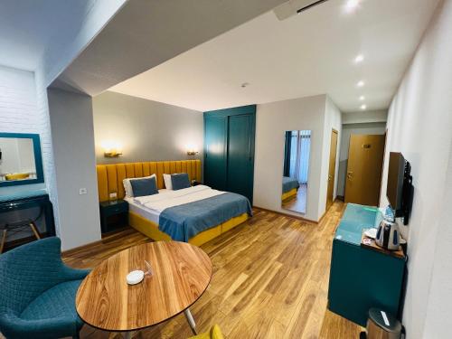 巴庫的住宿－CH Hotel，酒店客房配有一张床铺和一张桌子。
