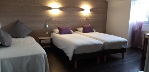 RouvrayにあるLogis Hôtel "Ici m'aime"のベッド2台(サイドサイドサイド)が備わるホテルルーム内のベッド2台